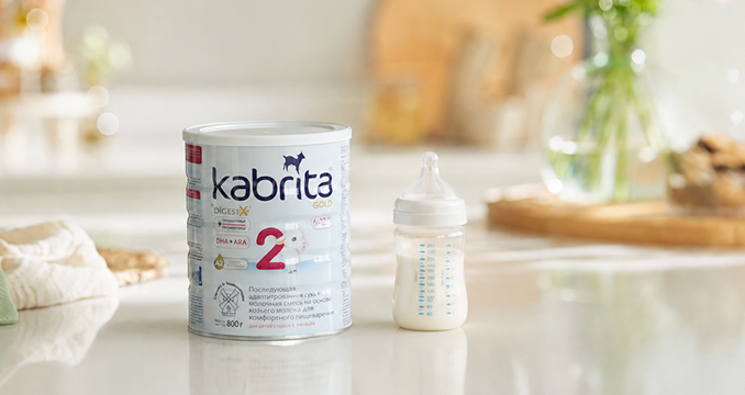 Детская молочная смесь Kabrita 2 рядом с бутылочкой